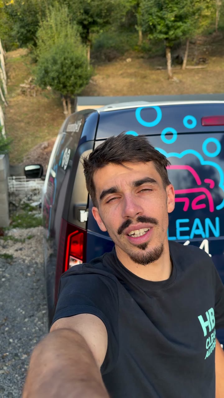 Alexis de HB Clean Auto 64 en selfie devant la camionnette floquée aux couleurs de l'entreprise