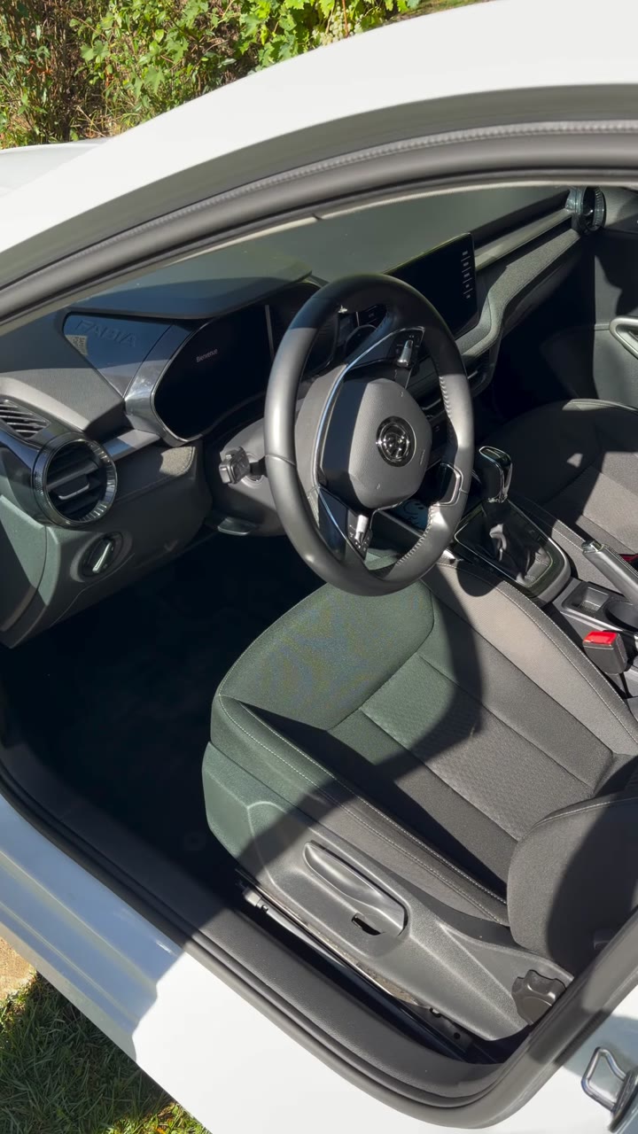 Habitacle de la Skoda Fabia après nettoyage : sol, siège conducteur et volant propres, vus de la porte avant